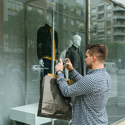 man-taking-photo-shop-window-fashion-store